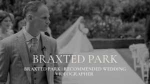Braxted Park Recommended Wedding Videographer - A black and white photograph of a groom turning his head to see his bride walking down the aisle during an outdoor ceremony at Braxted Park.