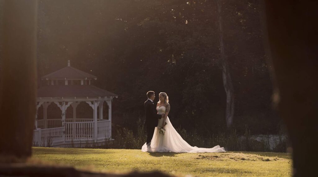 Creeksea Place wedding photography; romantic bride and groom portrait backlit by the golden hour sun with the lake and pergola in the background.