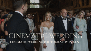 Documentary wedding film still of a bride walking down the aisle at a luxury Kent venue; high-energy ceremony moment with beaming guests.