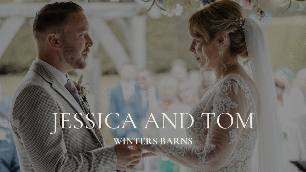 Cinematic wedding videography still in Canterbury; shallow depth-of-field ceremony shot at Winters Barns featuring a backlit couple.