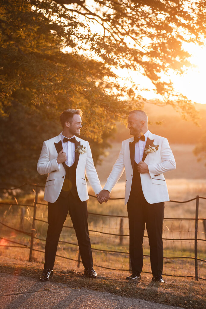 Essex wedding photographer; Gaynes Park; stunning portrait of two grooms looking at each other; luxury same-sex wedding photography; sunset at Epping Woodland.